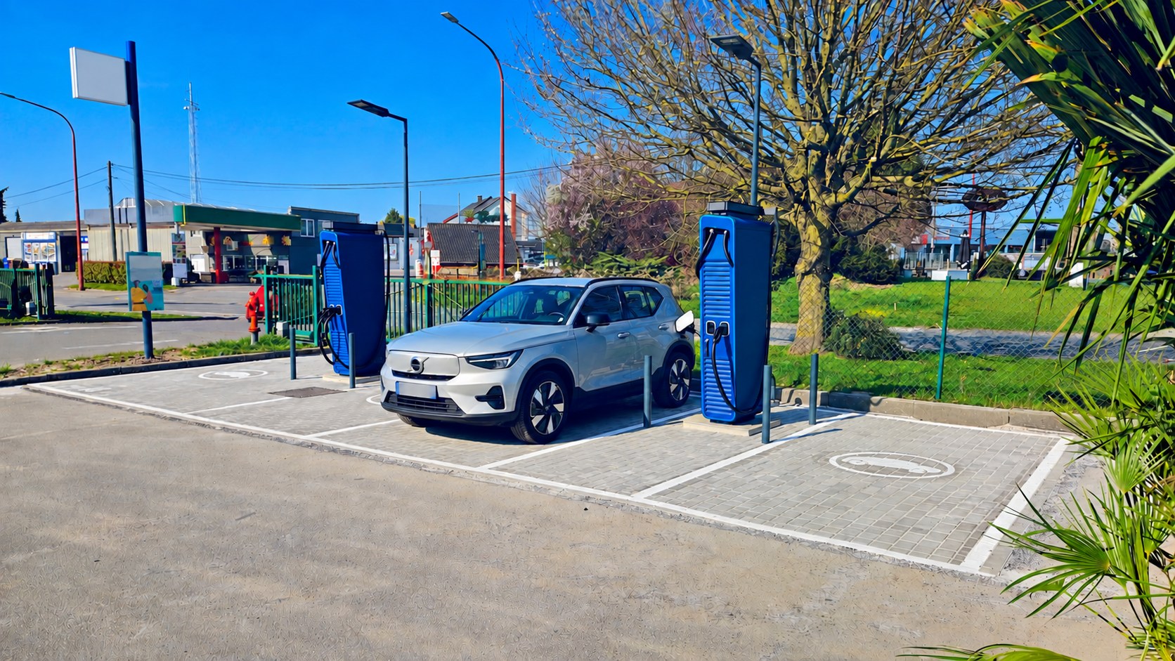 Station belge en service avec deux bornes rapides et un véhicule électrique